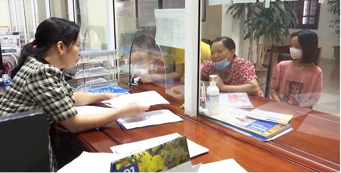 Cán bộ BHXH tỉnh Hà Nam hướng dẫn người dân làm thủ tục. Ảnh: BH
