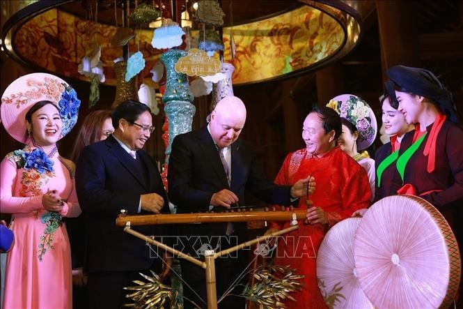 Thủ tướng New Zealand Christopher Luxon trải nghiệm nhạc cụ truyền thống Việt Nam. Ảnh: Dương Giang/TTXVN