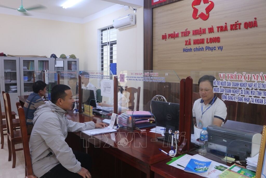 Người dân đến làm thủ tục hành chính tại bộ phận một cửa xã Nghi Long (Nghi Lộc, Nghệ An). Ảnh: Bích Huệ/TTXVN