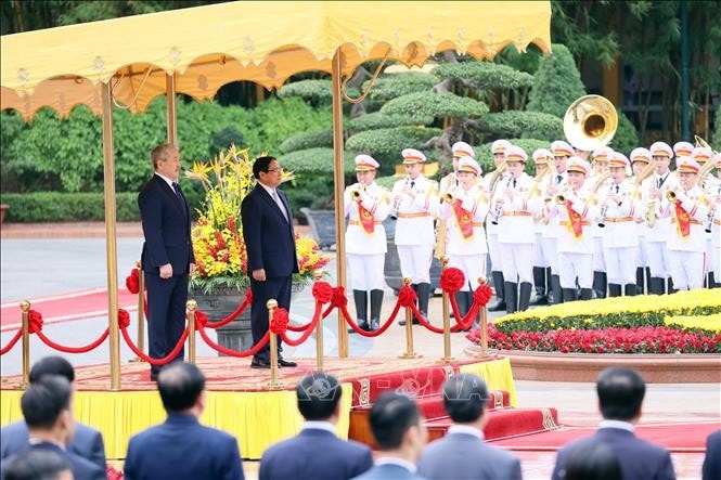 Thủ tướng Phạm Minh Chính và Thủ tướng Kyrgyzstan Adylbek Kasimalyev nghe quân nhạc cử Quốc thiều hai nước. Ảnh: An Đăng/TTXVN