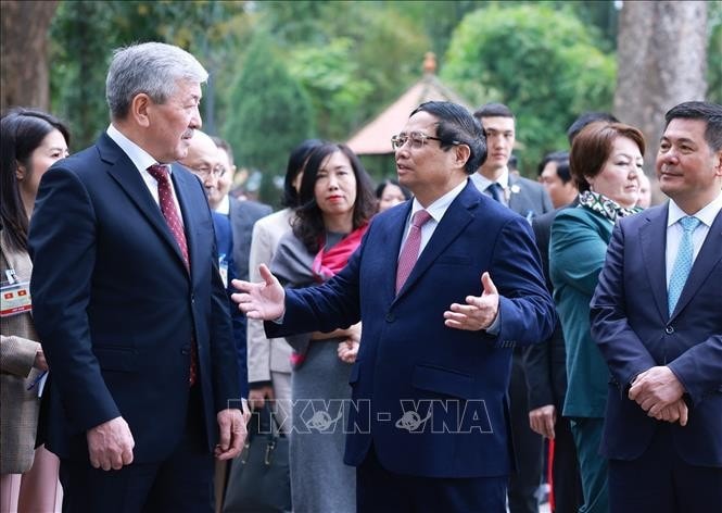 Thủ tướng Phạm Minh Chính giới thiệu với Thủ tướng Kyrgyzstan Adylbek Kasimalyev Di tích Nhà sàn Bác Hồ. Ảnh: Dương Giang/TTXVN