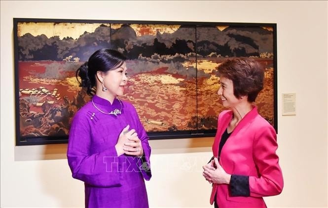 Phu nhân Ngô Phương Ly (trái) chia sẻ với Quốc vụ khanh Singapore, bà Low Yen Ling những nét đặc sắc của nền hội họa Việt Nam. Ảnh: TTXVN