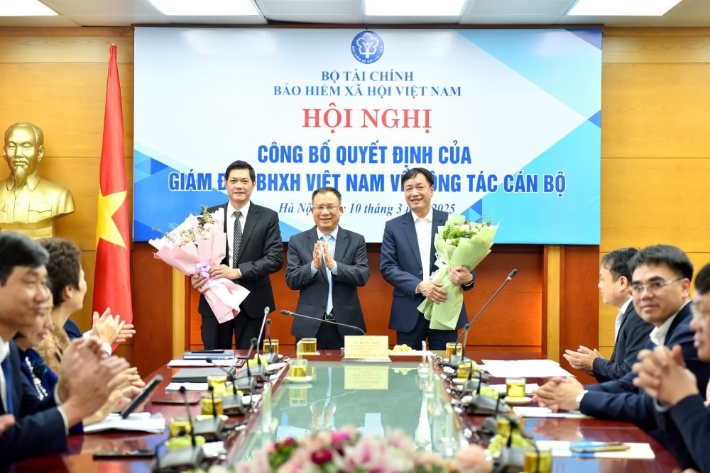 Giám đốc BHXH Việt Nam Lê Hùng Sơn tặng hoa chúc mừng ông Phan Văn Mến (bên phải) và ông Nguyễn Ngọc Huyện (bên trái).