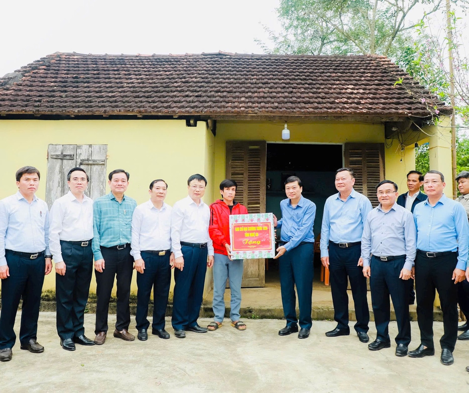 Phó Bí thư Tỉnh ủy, Chủ tịch UBND tỉnh Lê Hồng Vinh tặng quà gia đình anh Phạm Hữu Chung (huyện Tân Kỳ) bên ngôi nhà cũ. Ảnh: H.Phong