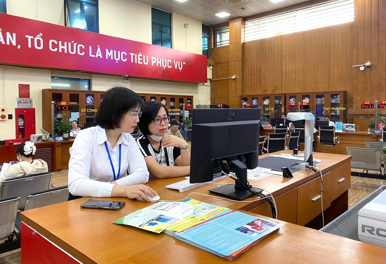 Công chức Một cửa tại Trung tâm Phục vụ hành chính công tỉnh Bắc Giang hướng dẫn công dân nộp hồ sơ trực tuyến. Ảnh: ITN