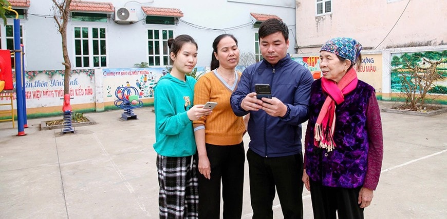 Cán bộ xã Vũ Di hướng dẫn người dân thôn Yên Trình thực hiện các giao dịch trên nền tảng số. Ảnh: Khánh Linh