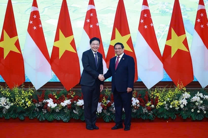 Prime Minister Pham Minh Chinh (R) shakes hands with his Sngaporean counterpart Lawrence Wong in Hanoi on March 26. (Photo: VNA) z6443885567135-92d8e68711f53002ed99c75627423056.jpg