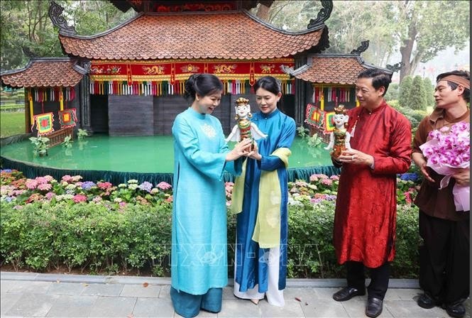 Bà Ngô Phương Ly, Phu nhân Tổng Bí thư Tô Lâm tặng con rối nước cho bà Loo Tze Lui, Phu nhân Thủ tướng Singapore Lawrence Wong. Ảnh: Phạm Kiên/TTXVN