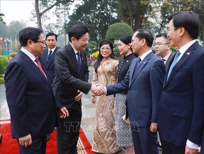 Thủ tướng Phạm Minh Chính giới thiệu với Thủ tướng Singapore Lawrence Wong thành viên đoàn Việt Nam. Ảnh: Dương Giang/TTXVN