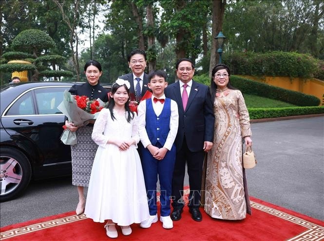 Thủ tướng Phạm Minh Chính và Phu nhân cùng Thủ tướng Singapore Lawrence Wong và Phu nhân tại Lễ đón. Ảnh: Dương Giang/TTXVN