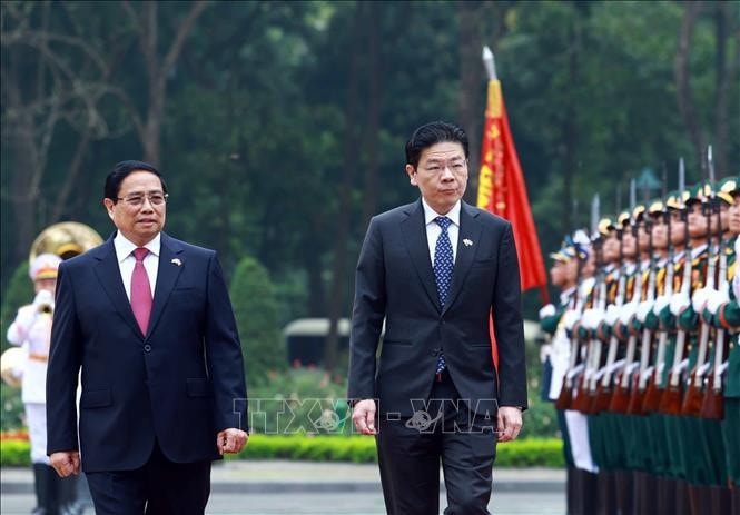 Thủ tướng Phạm Minh Chính và Thủ tướng Singapore Lawrence Wong duyệt Đội danh dự Quân đội nhân dân Việt Nam. Ảnh: Dương Giang/TTXVN