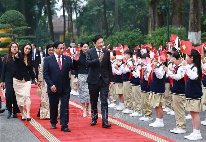 Thủ tướng Phạm Minh Chính và Phu nhân cùng Thủ tướng Singapore Lawrence Wong và Phu nhân với thiếu nhi Thủ đô. Ảnh: Dương Giang/TTXVN