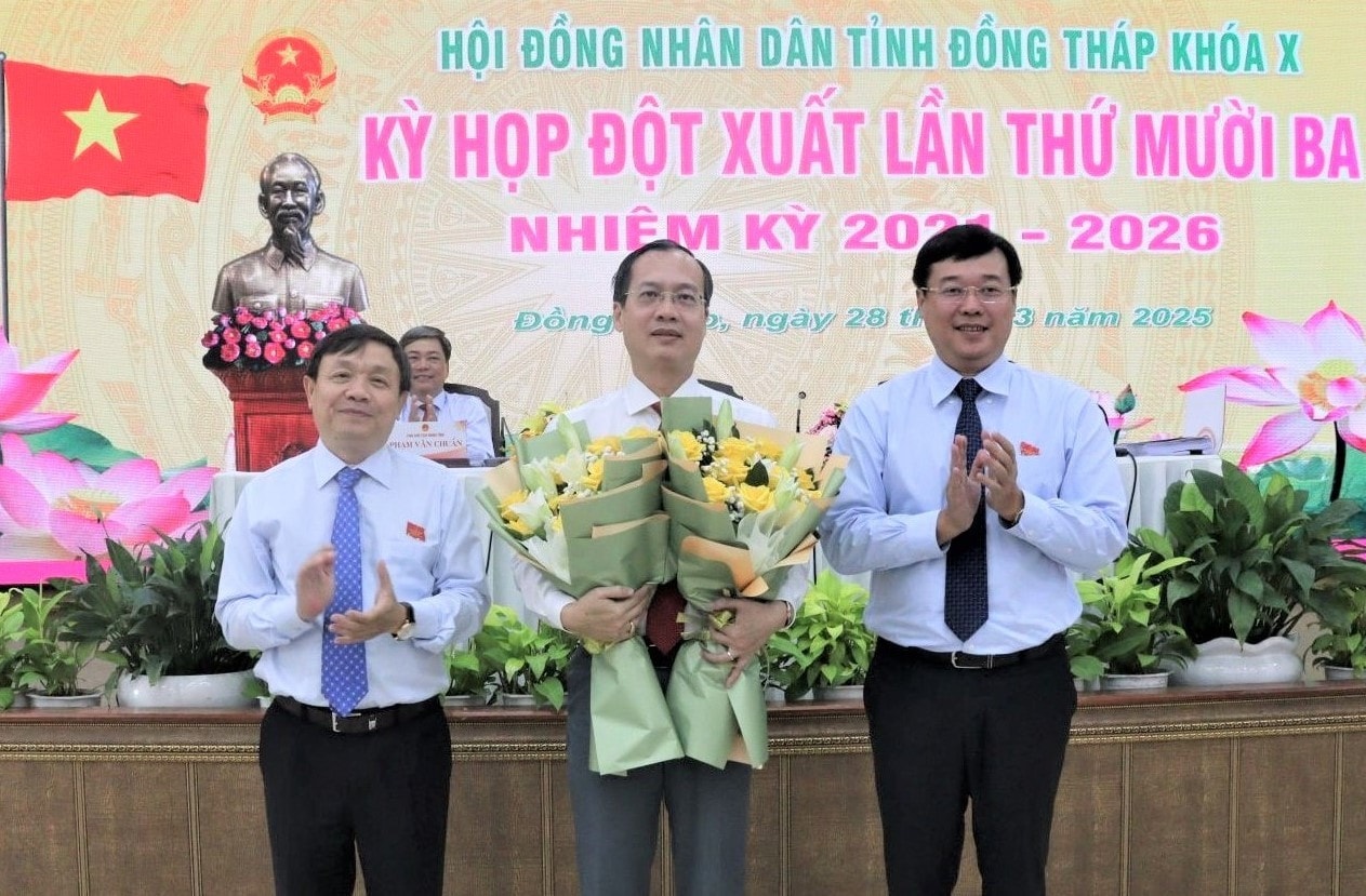 Bí thư Tỉnh ủy, Trưởng Đoàn ĐBQH tỉnh Lê Quốc Phong (bên phải) và Phó Bí thư Thường trực Tỉnh ủy, Chủ tịch HĐND tỉnh Phan Văn Thắng tặng hoa chúc mừng Chủ tịch UBND tỉnh Trí Quang. Ảnh: Khải Hân