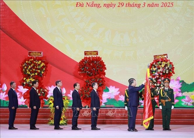 Tổng Bí thư Tô Lâm gắn Huân chương Lao động hạng Nhất lên Cờ truyền thống của thành phố Đà Nẵng. Ảnh: Thống Nhất/TTXVN