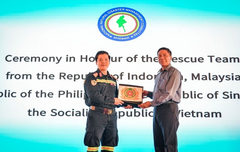 Đại tá Nguyễn Minh Khương, Trưởng đoàn cứu nạn, cứu hộ Bộ Công an Việt Nam trao quà tặng Tiến sĩ Soe Win, Bộ trưởng Bộ Phúc lợi xã hội, cứu trợ và tái định cư Myanmar