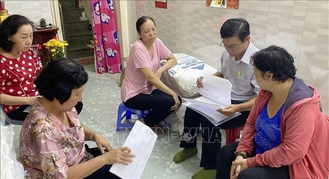 The inspection team on the implementation of the sustainable poverty reduction programme for the 2021-2025 period reviews the list of poor and near-poor households in HCM City’s District 5 (Photo: VNA) The inspection team on the implementation of the sustainable poverty reduction programme for the 2021-2025 period reviews the list of poor and near-poor households in HCM City’s District 5 (Photo: VNA)