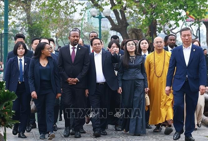 Thủ tướng Phạm Minh Chính và Phu nhân cùng Thủ tướng Ethiopia Abiy Ahmed Ali và Phu nhân nghe giới thiệu về văn hoá, lịch sử, kiến trúc chùa Trấn Quốc. Ảnh: Dương Giang/TTXVN