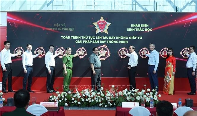 Thủ tướng Phạm Minh Chính và các đại biểu bấm nút triển khai giải pháp ứng dụng định danh, xác thực điện tử và nhận diện sinh trắc học phục vụ thủ tục lên tàu bay. Ảnh: Dương Giang/TTXVN