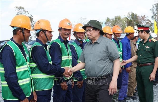Thủ tướng Phạm Minh Chính thăm, động viên công nhân, kỹ sư thi công dự án đường bộ cao tốc Cần Thơ - Cà Mau đoạn qua thành phố Cà Mau. Ảnh: Dương Giang/TTXVN