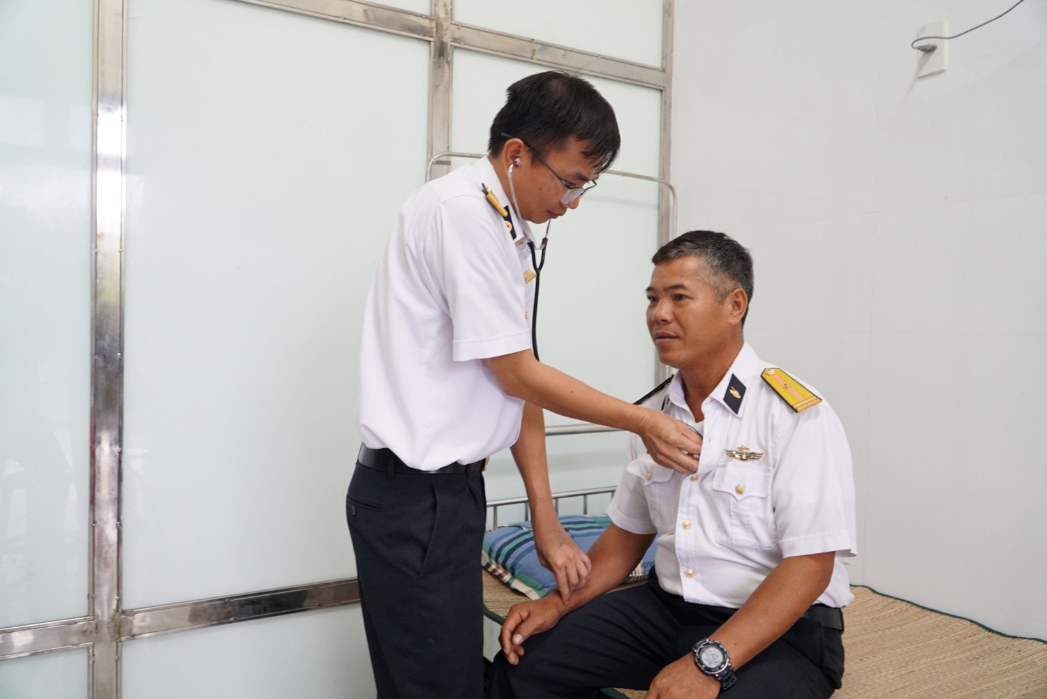Bác sĩ CK1, Đại úy Lê Đăng Tuấn (Trạm trưởng Bệnh xá đảo Sinh Tồn) khám bệnh cho một cán bộ trên đảo