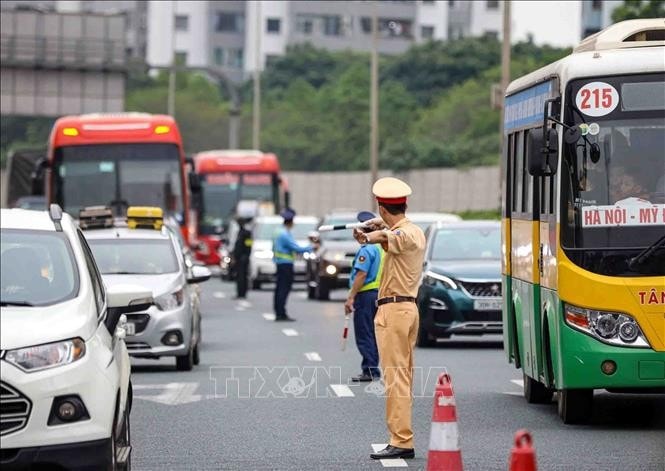 Lực lượng CSGT tổ chức phân luồng, điều tiết giao thông tại cuối cao tốc Pháp Vân - Cầu Giẽ hướng vào trung tâm Thủ đô. Ảnh minh họa: Phạm Kiên/TTXVN