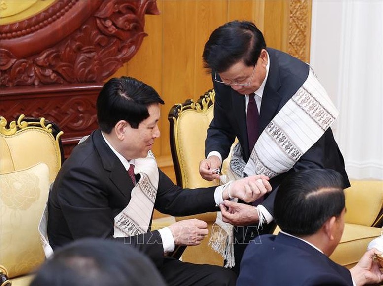 Tổng Bí thư, Chủ tịch nước Lào Thongloun Sisoulith buộc chỉ cho Chủ tịch nước Lương Cường. Ảnh: TTXVN