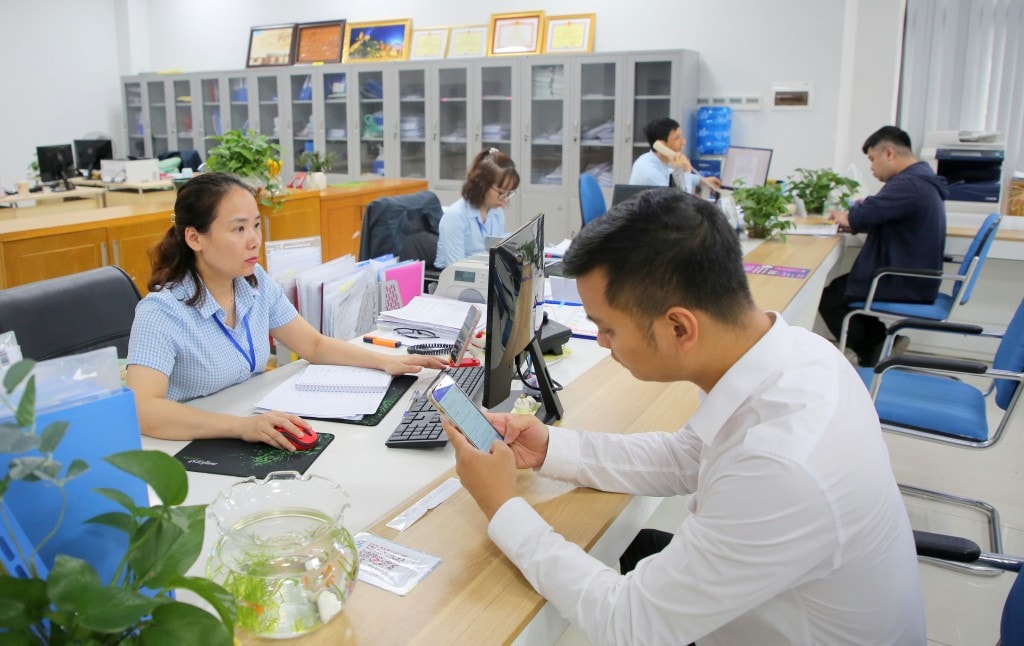 Cán bộ Trung tâm Phục vụ hành chính công tỉnh Quảng Ninh hướng dẫn, hỗ trợ người dân, doanh nghiệp giải quyết thủ tục hành chính. Ảnh: Song Hà