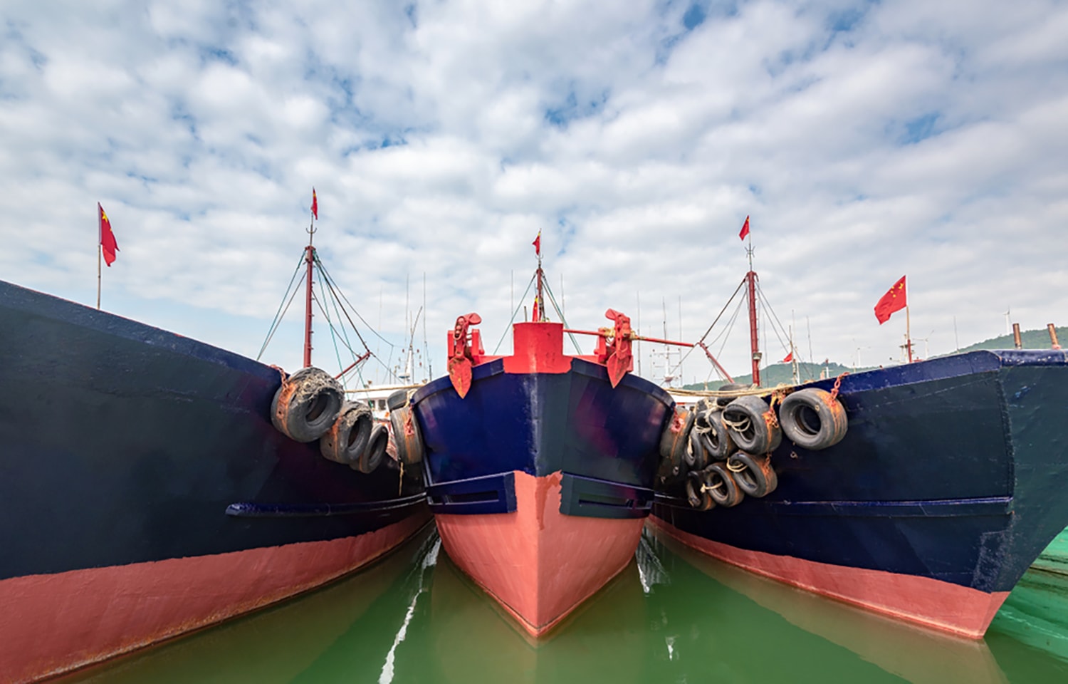 Three Chinese fishing boats moored together at a port