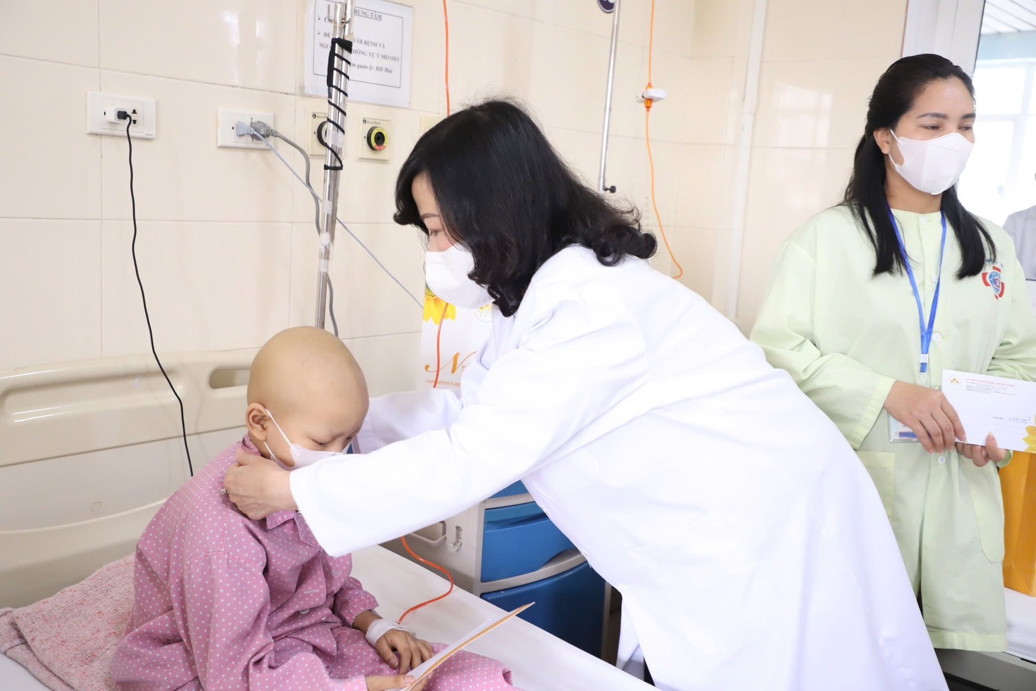 Bộ trưởng Bộ Y tế Đào Hồng Lan ân cần, thăm hỏi sức khỏe bệnh nhi và người nhà bệnh nhi.