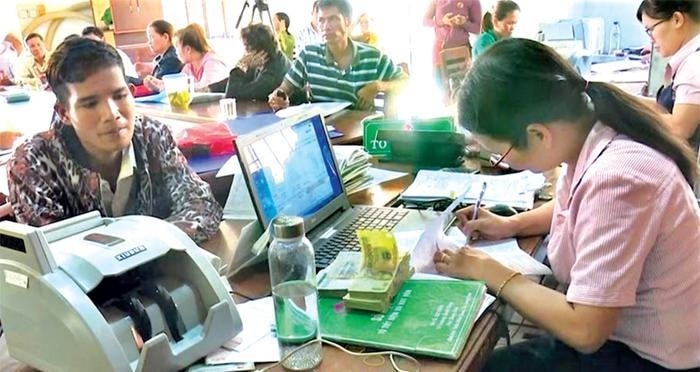 Ảnh 2- Người dân nhận vốn vay ngay tại điểm giao dịch của Ngân hàng Chính sách Xã hội huyện Minh Long (Quảng Ngãi). Ảnh dtnvn