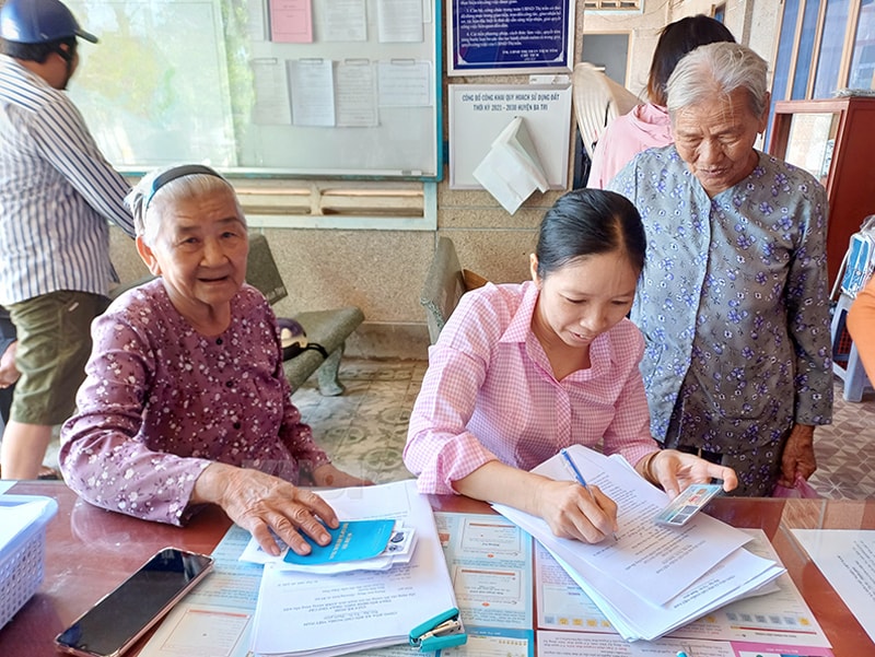 Cán bộ thị trấn Tiệm Tôm tích cực tuyên truyền, vận động người dân tham gia các chính sách BHXH, BHYT. Ảnh Phan Hân