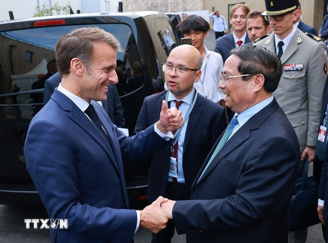 Prime Minister Pham Minh Chinh (R) is welcomed by French President Emmanuel Macron (Photo: VNA) pham-minh-chinh-3.jpg