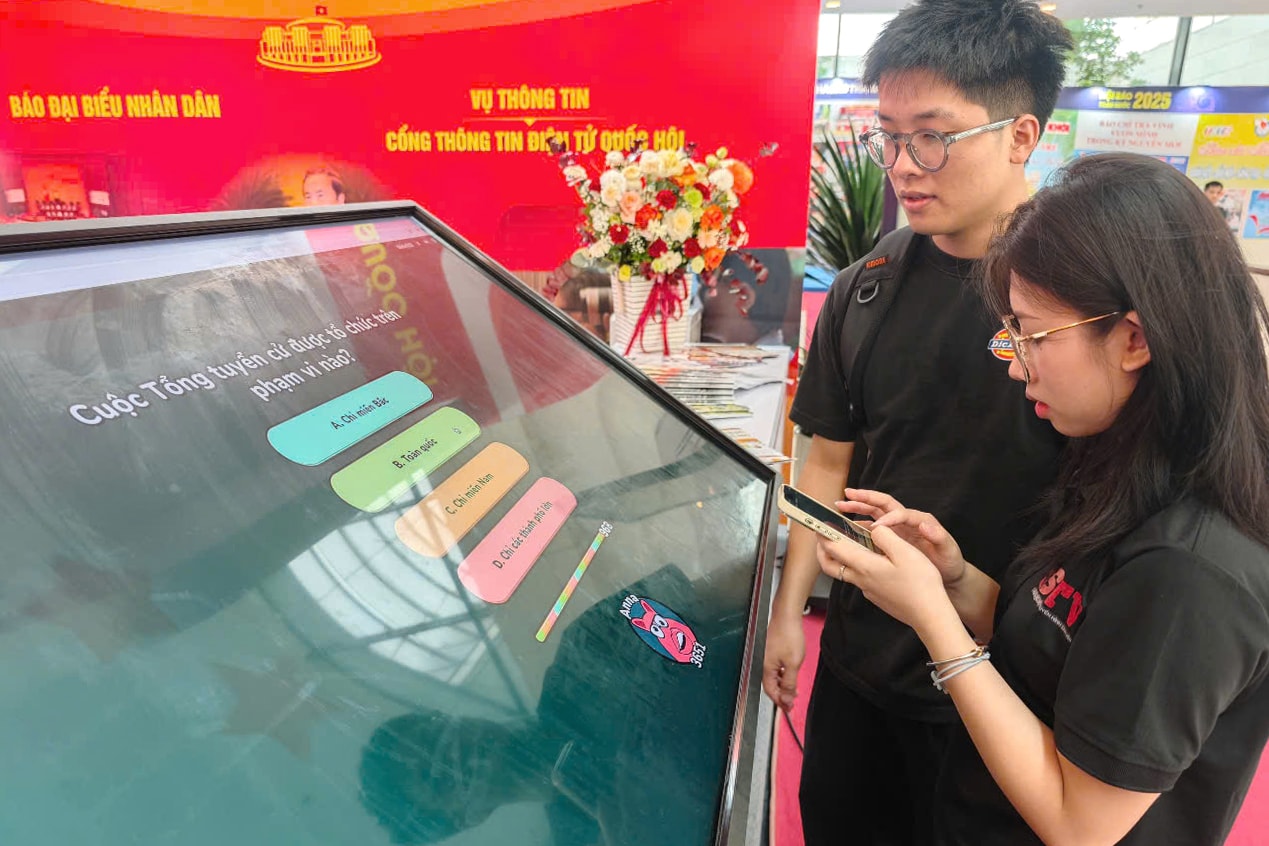 khách tham quan trả lời câu hỏi về Quốc hội tại gian báo Đại biểu nhân dân