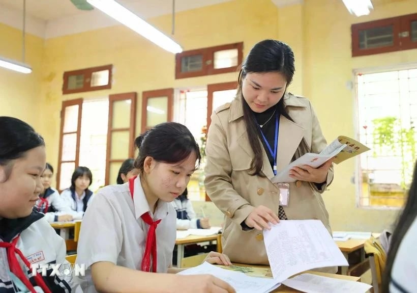 A teacher guiding her students in revision ahead of an examination. (Photo: VNA)