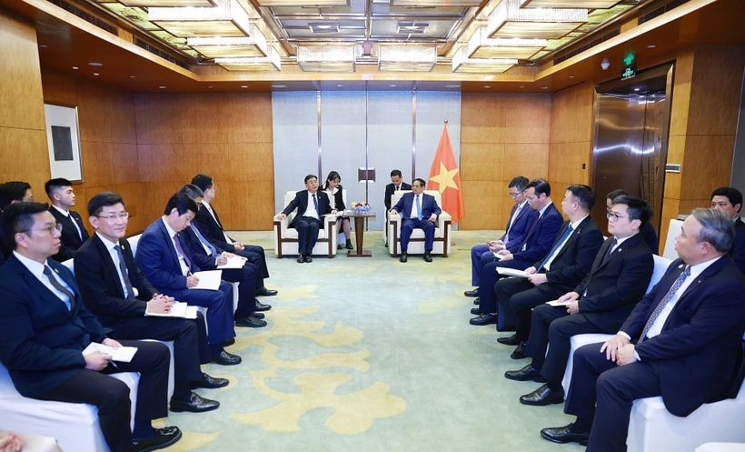 Prime Minister Pham Minh Chinh (right) works with Vice Chairman of COMAC Shen Bo. (Photo: VNA)