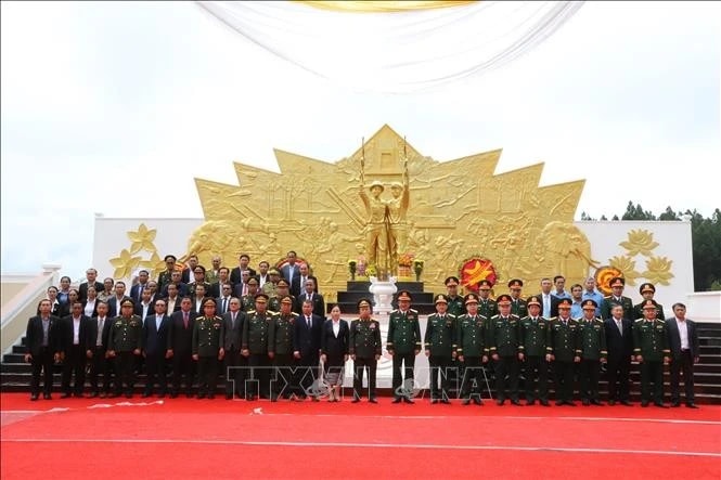 Delegates pose for a group photo at the Vietnam-Laos combat alliance monument in the southern Lao province of Champasak on July 1. (Photo: VNA)
