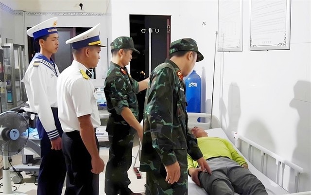 Doctors from Naval Region 4 Command provide emergency medical care to a fisherman who fell ill while working at sea. (Photo: VNA)