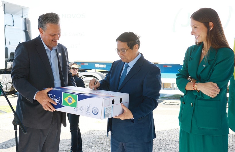 PM Pham Minh Chinh (C) signs on a pack of beef exported to Vietnam. (Photo: VNA)
