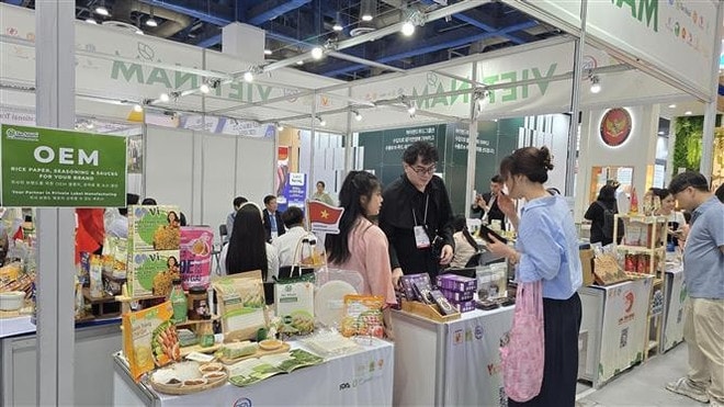 Foreign visitors explore the Vietnamese booth. (Photo:VNA) vna-potal-doan-doanh-nghiep-hang-viet-nam-chat-luong-cao-no-luc-chinh-phuc-thi-truong-han-quoc-8138018.jpg