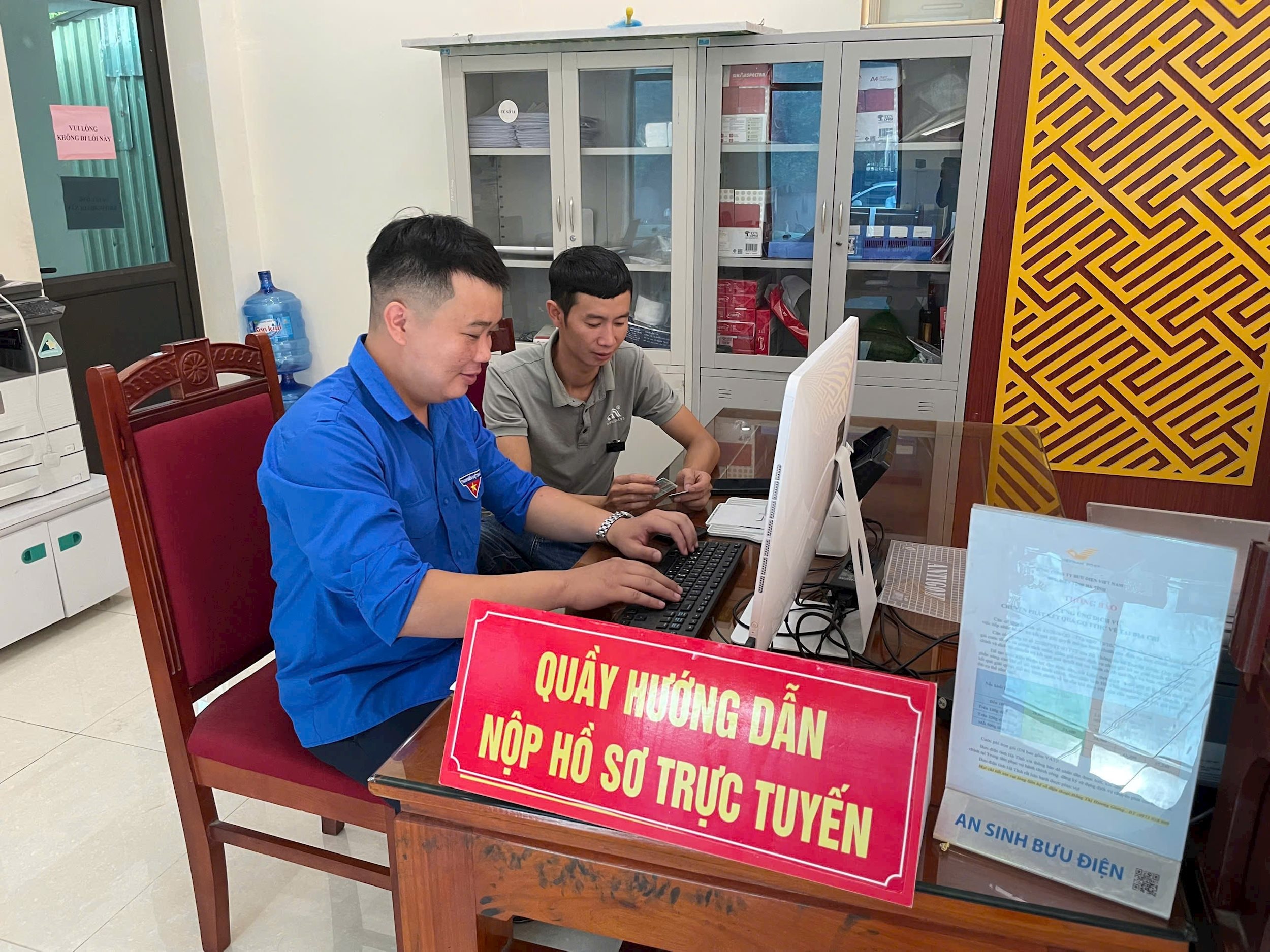 Đại biểu HĐND phường Nam hồng lĩnh, tỉnh Hà Tĩnh hướng dẫn cử tri nộp hồ sơ trực tuyến tại Trung tâm phục vụ hành chính công - ẢNH BÌNH NGUYÊN