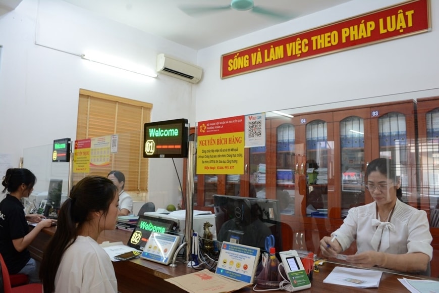 Cán bộ phường Xuân La, quận Tây Hồ, TP Hà Nội hướng dẫn người dân làm thủ tục hành chính. Ảnh minh hoạ qdnd.vn