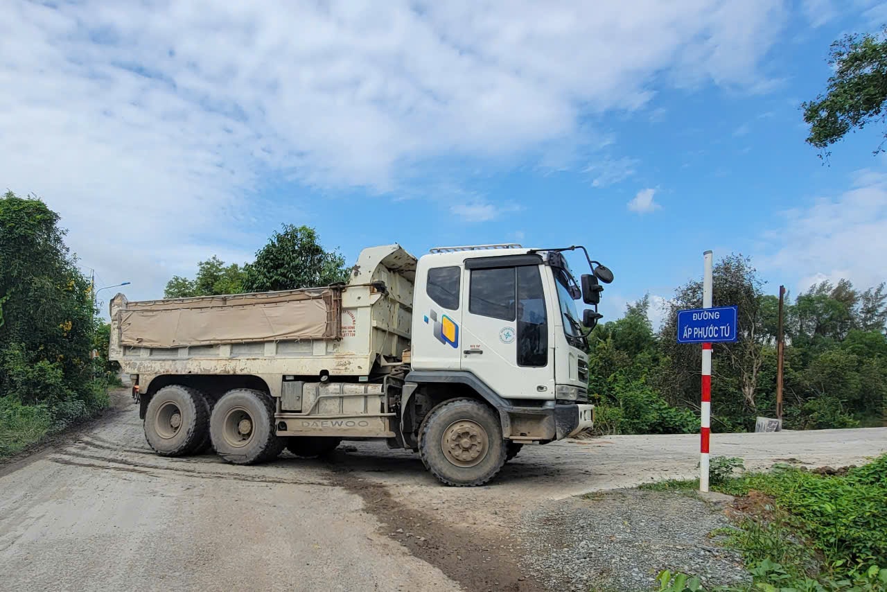 Sáng 29/7, xe ben hạng nặng vẫn tiếp tục vào ra tuyến đường ấp Phước Tú. Ảnh: Quang Phương