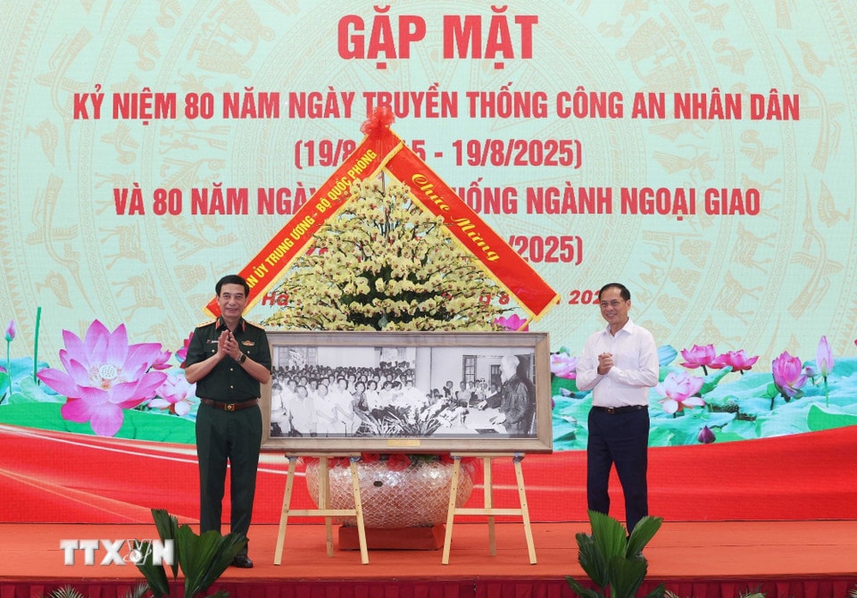 Đại tướng Phan Văn Giang, Ủy viên Bộ Chính trị, Phó Bí thư Quân ủy Trung ương, Bộ trưởng Bộ Quốc phòng tặng bức ảnh “Chủ tịch Hồ Chí Minh dự và nói chuyện tại Hội nghị ngoại giao lần thứ nhất năm 1957” cho đồng chí Bùi Thanh Sơn, Ủy viên Trung ương Đảng, Phó Thủ tướng Chính phủ, Bộ trưởng Bộ Ngoại giao. (Ảnh: Thống Nhất - TTXVN)