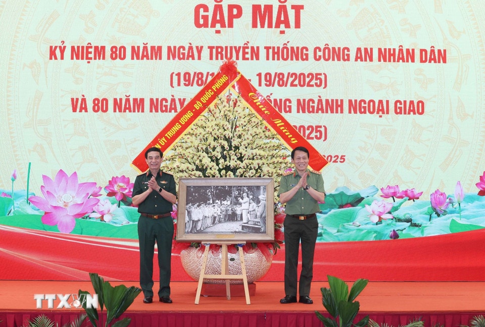Đại tướng Phan Văn Giang, Ủy viên Bộ Chính trị, Phó Bí thư Quân uỷ Trung ương, Bộ trưởng Bộ Quốc phòng tặng bức ảnh “Chủ tịch Hồ Chí Minh thăm đơn vị Cảnh sát nhân dân Thủ đô ngày 14/02/1961” cho Đại tướng Lương Tam Quang, Ủy viên Bộ Chính trị, Bí thư Đảng uỷ Công an Trung ương, Bộ trưởng Bộ Công an. (Ảnh: Thống Nhất/TTXVN)