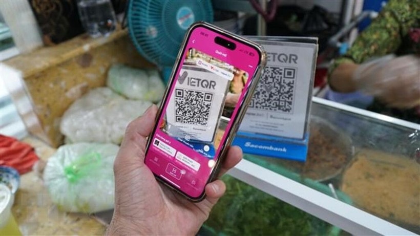 A local resident makes a bank transfer using the Momo app. (Photo: VNA)