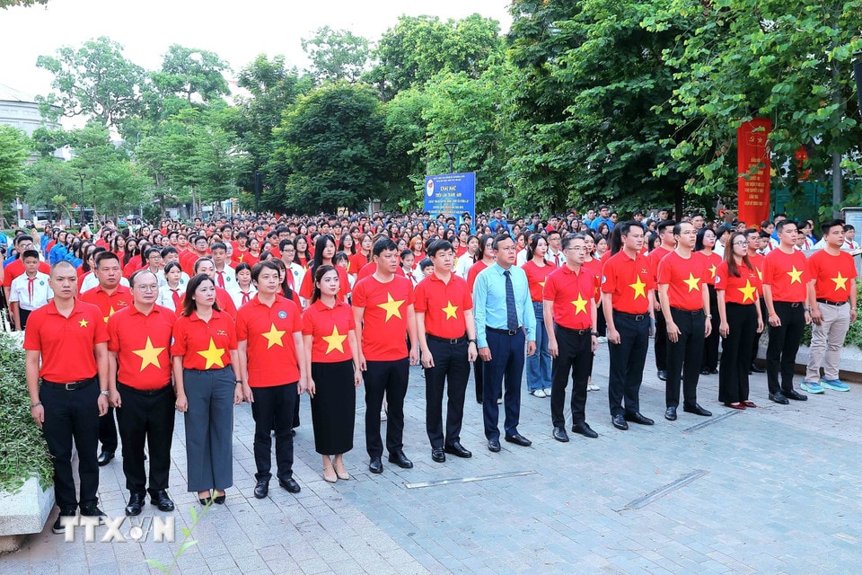 Các đại biểu và thanh niên, đoàn viên thực hiện nghi lễ chào cờ. (Ảnh: An Đăng/TTXVN)