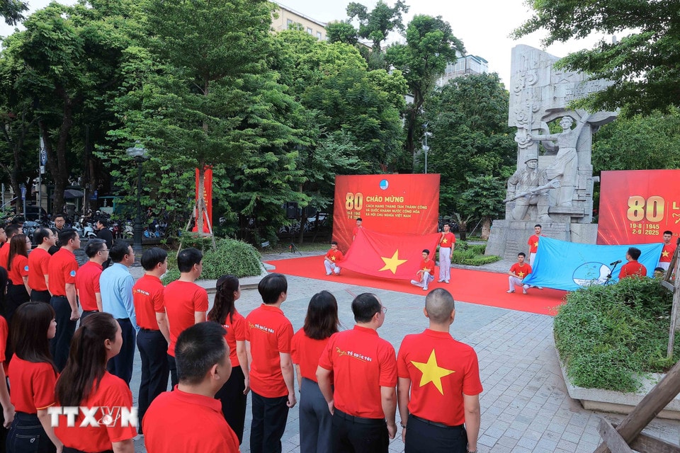 Các đại biểu và thanh niên, đoàn viên thực hiện nghi lễ chào cờ. (Ảnh: An Đăng/TTXVN)