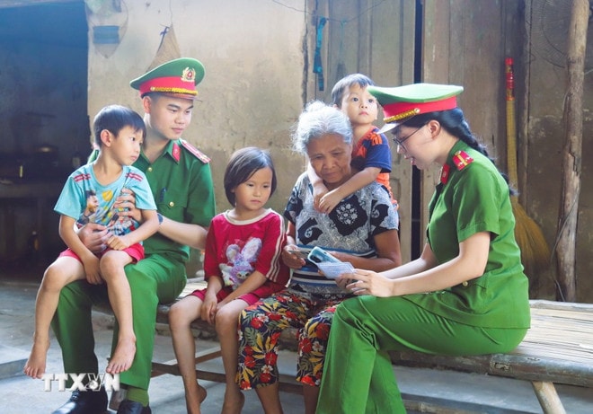 Commune-level public security officers directly go to households in each village and hamlet to guide people to install electronic identification and integrate health insurance cards into the VNeID application on their phones. (Photo: VNA) photo-3.jpg