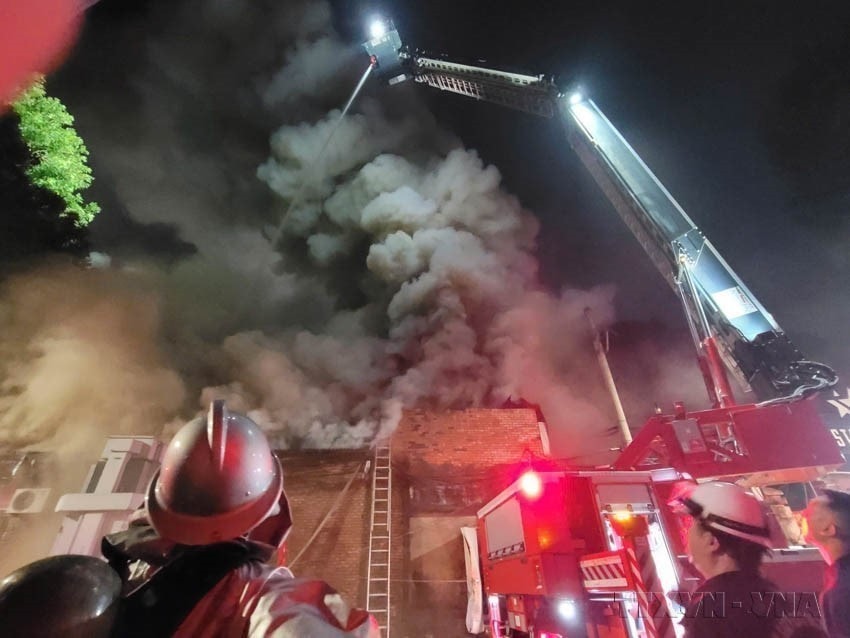 The fire and rescue force using modern equipment to extinguish a major blaze on Pho Duc Chinh Street, Hanoi. (Photo: VNA)