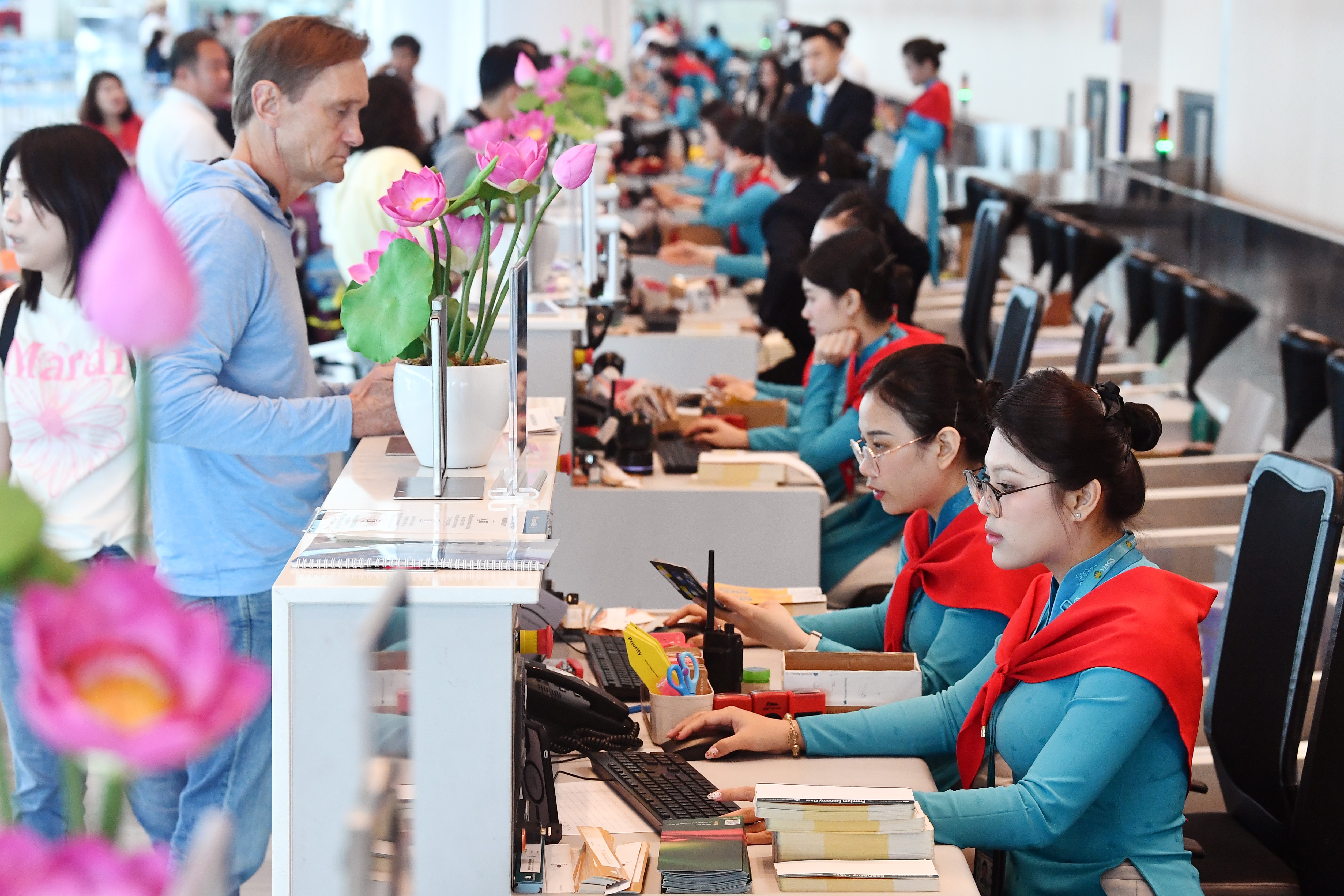 Ảnh 1 Quầy làm thủ tục tại sân bay rộn ràng sắc đỏ sao vàng, hành khách nhận thẻ lên tàu phiên bản đặc biệt in biểu tượng 2-9. Ảnh VNA